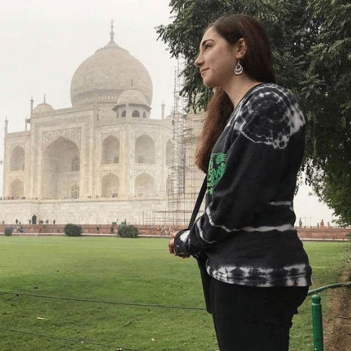Becca stands looking off into the distance with the Taj Mahal in the background