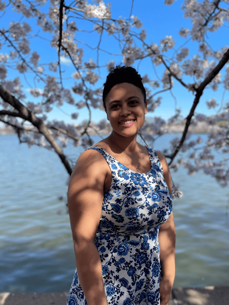A woman standing in front of the Potomac river smiling 