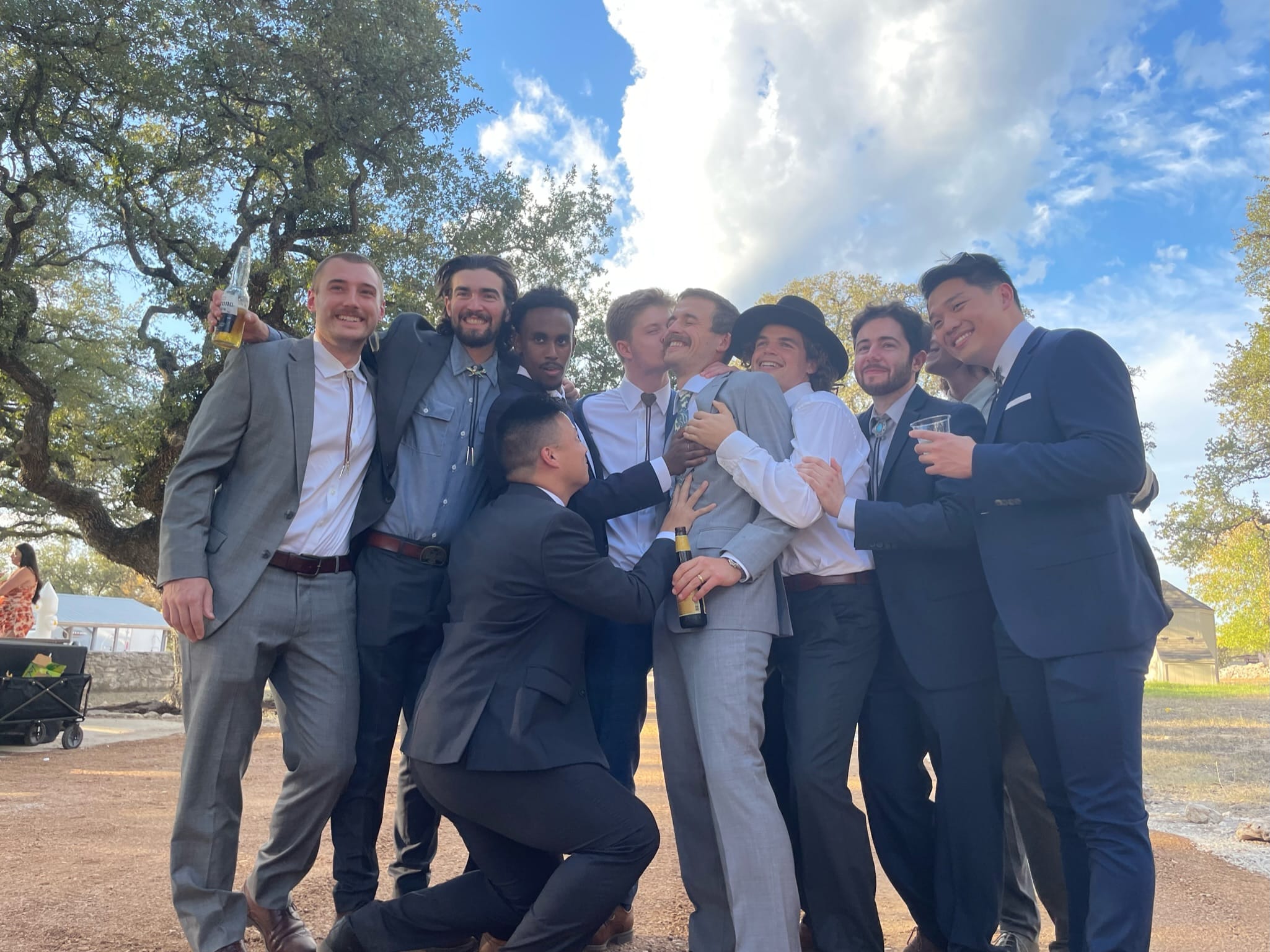 Samuel and a group of friends in suits before a wedding