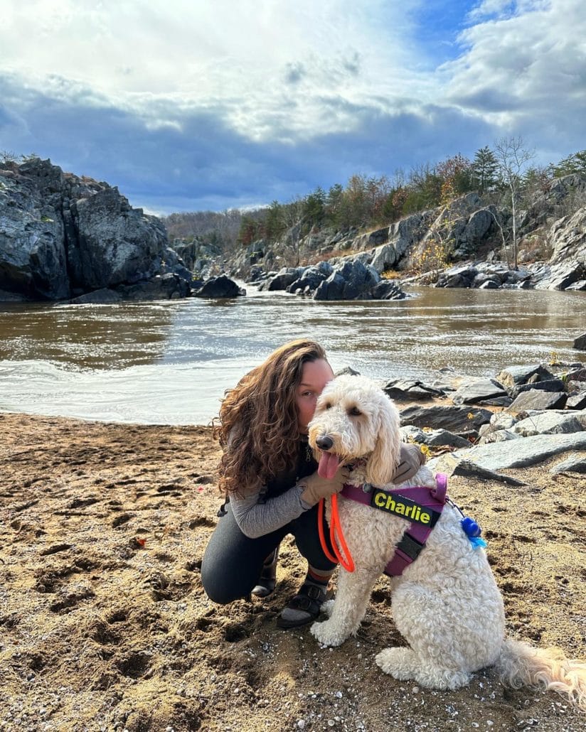 Delanie and her dog, Charlie, on a lake shore. 