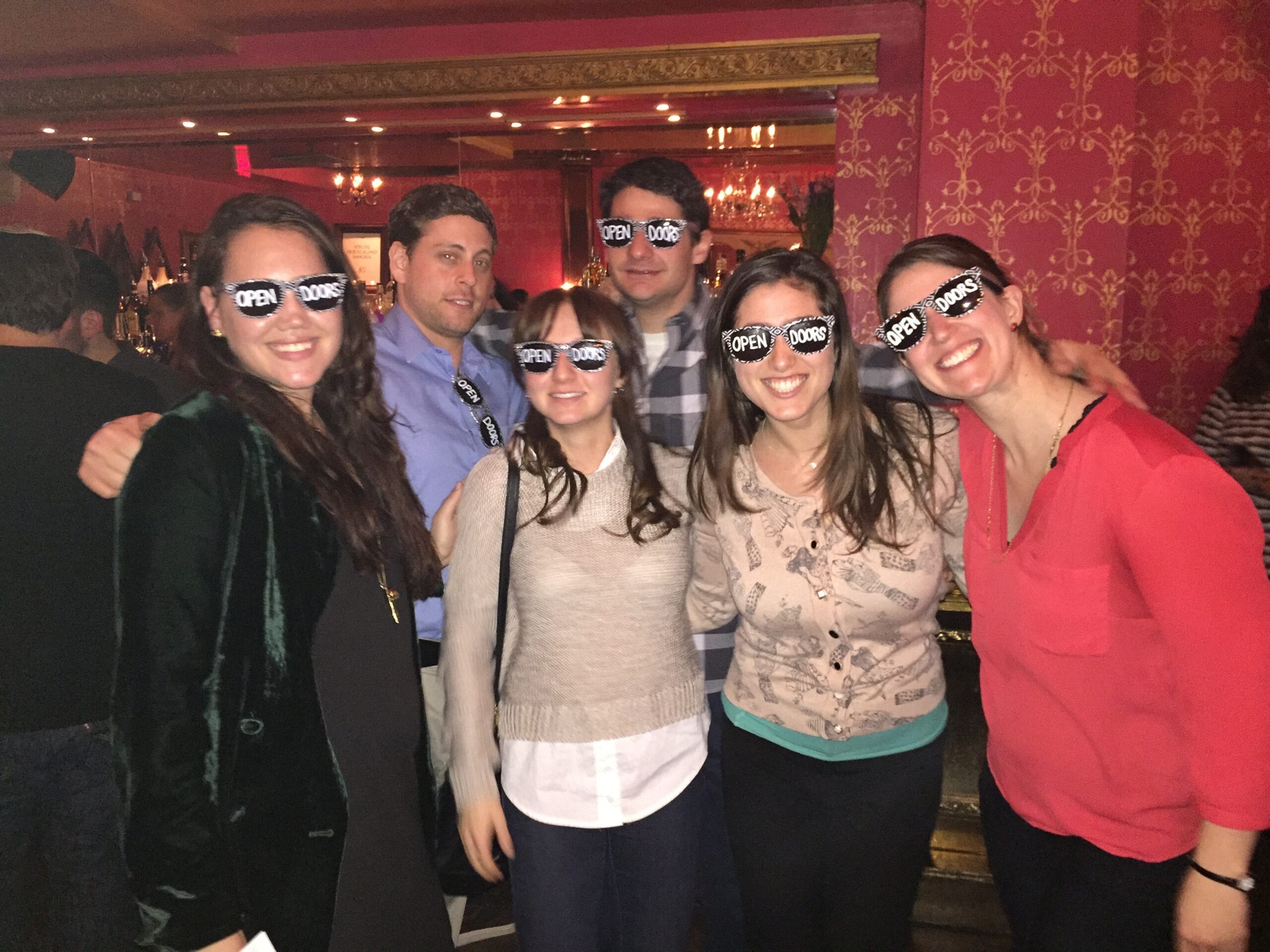 Gather staff and Open Doors fellows pose together in ODF-branded sunglasses at an event. 
