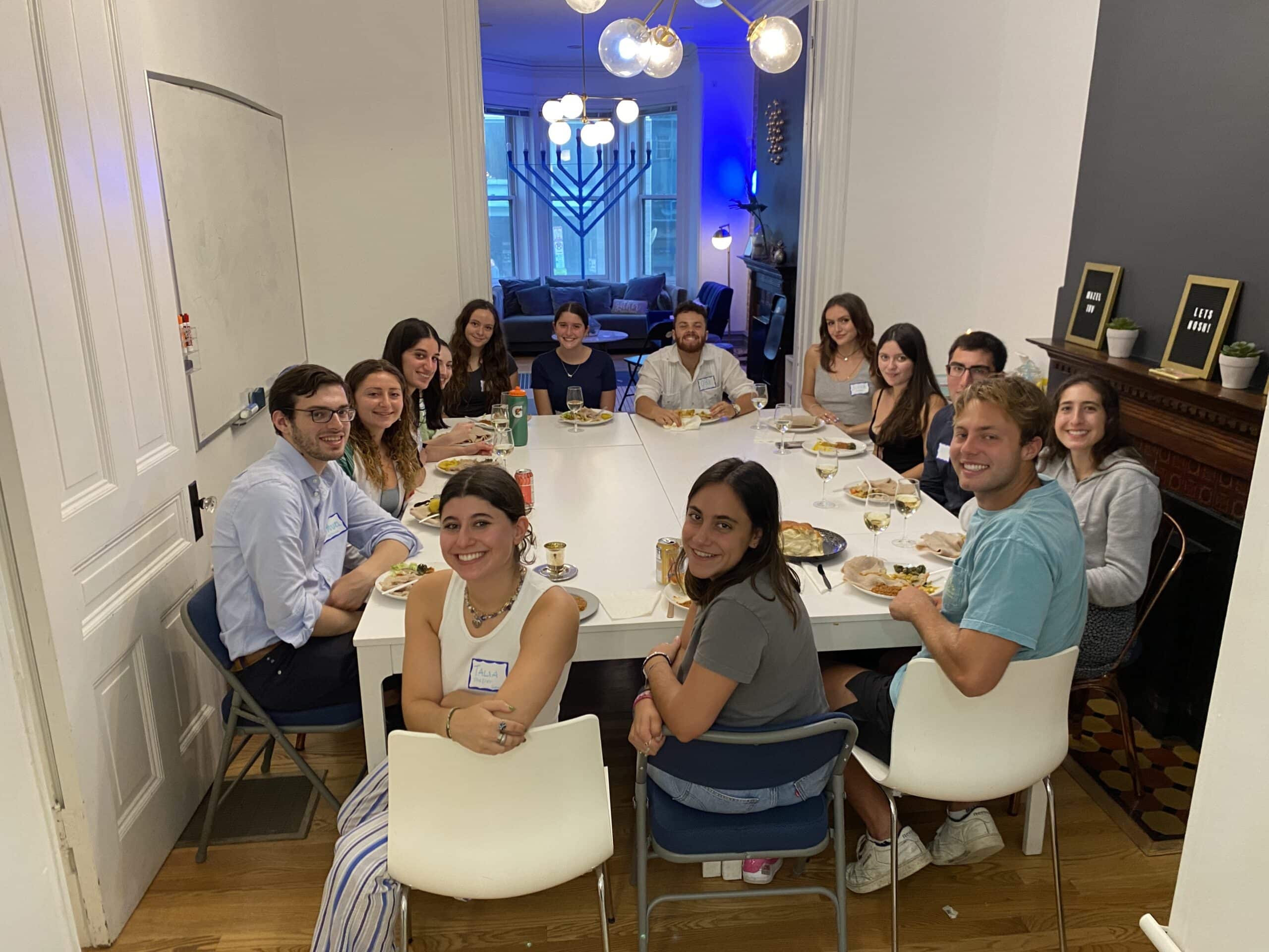 GatherDC hosts a Shabbat dinner in summer 2022. The townhouse dining room table is full. 