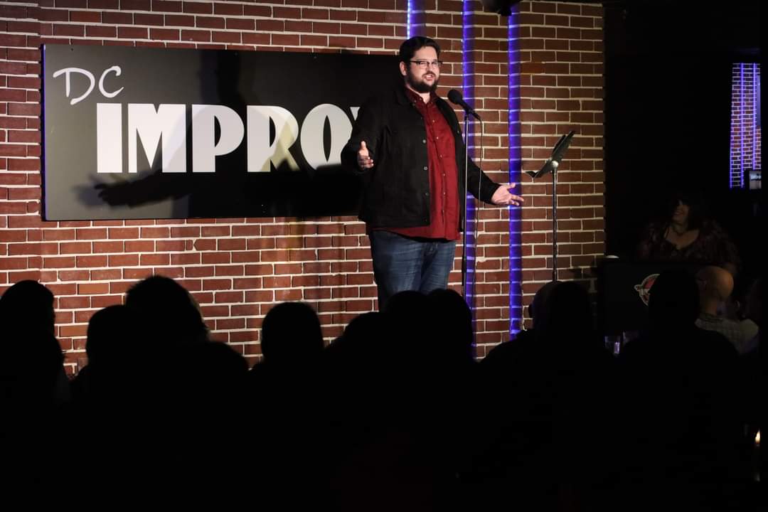 AJ alone onstage at the DC Improv. 