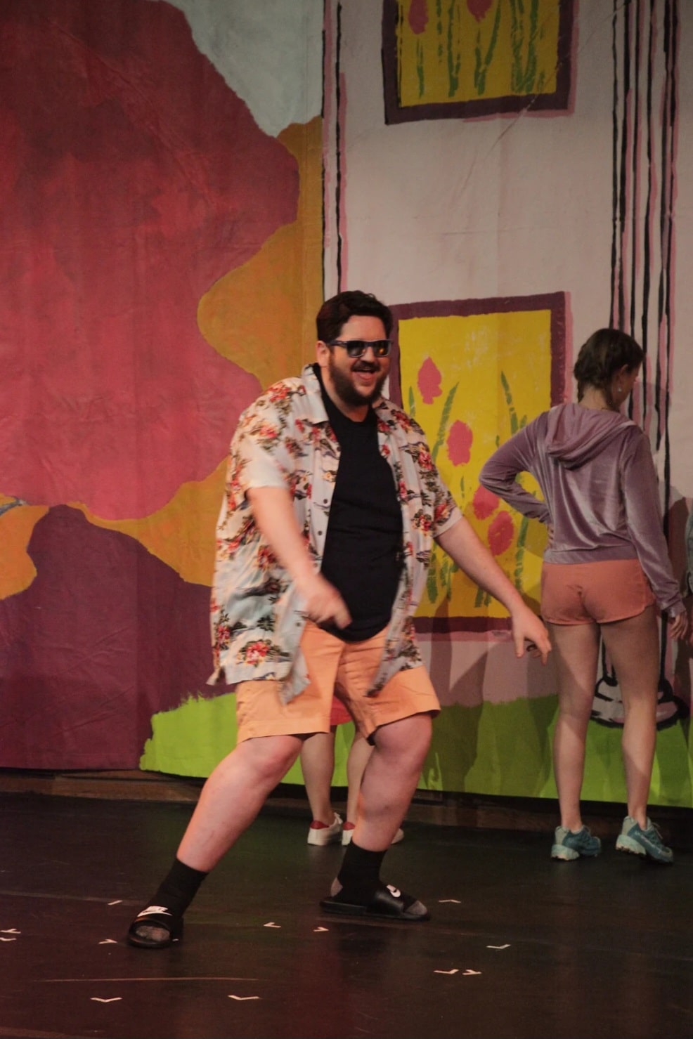 AJ performs in a play, dressed in sunglasses and a Hawaiian shirt. 