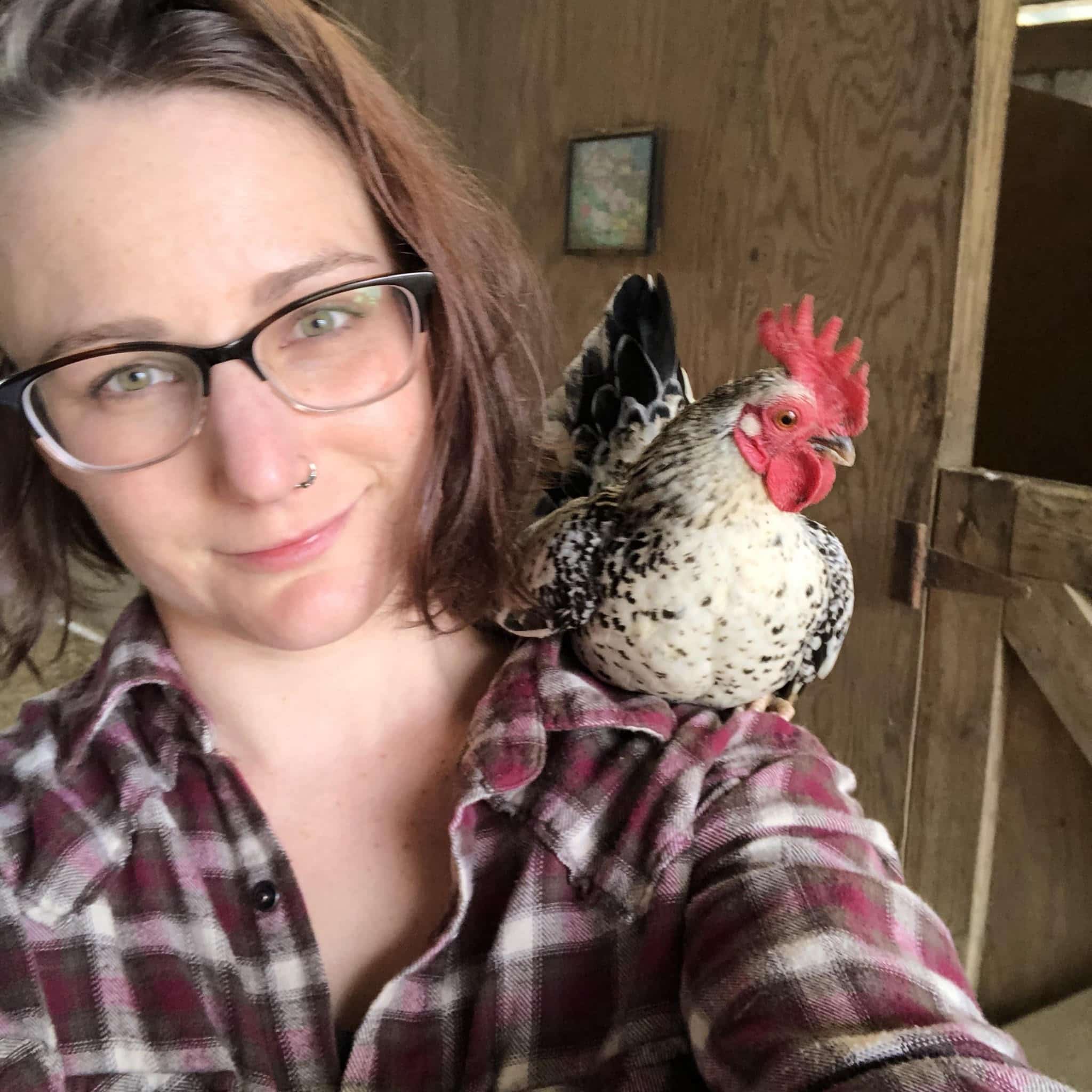 Amelia with a chicken perched on their shoulder. 