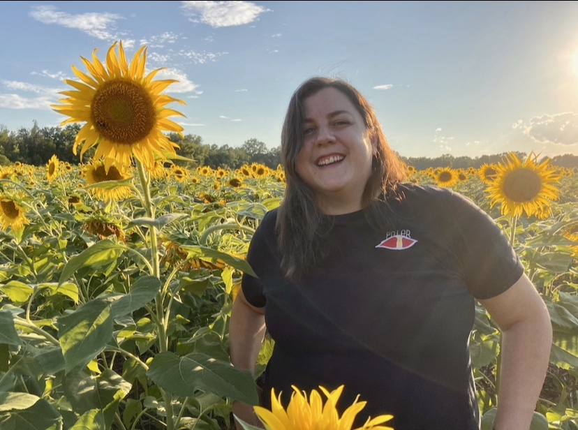 Hensch smiling in a field of sunflowers.