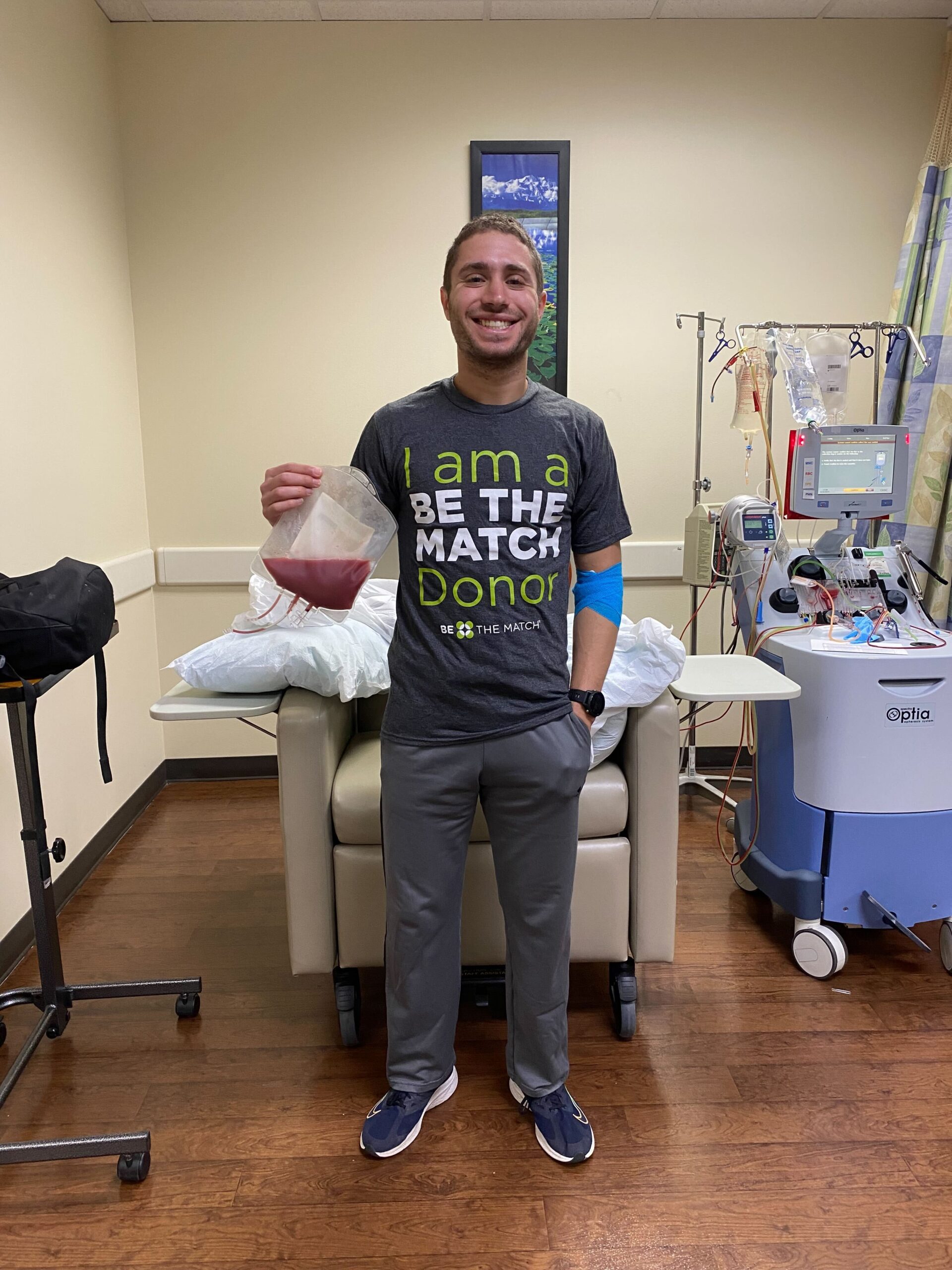 Zach holding a bag of stem cells and plasma after his donation. 
