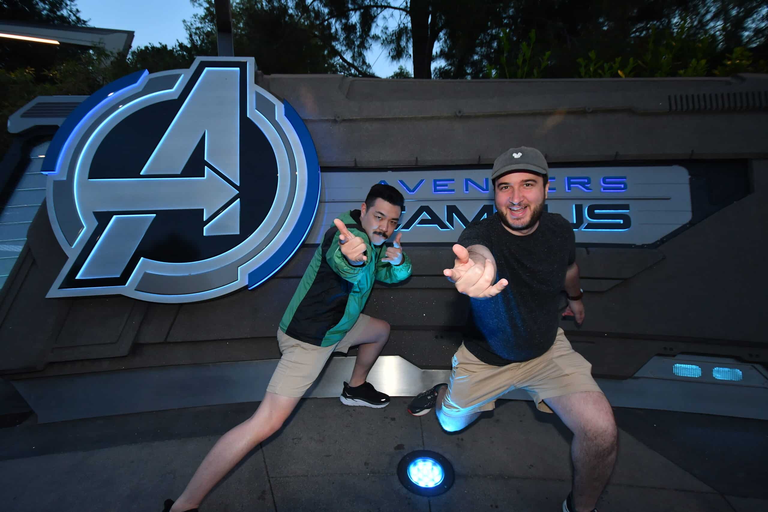 Josh and a friend pose ahead of an Avengers Campus sign. 