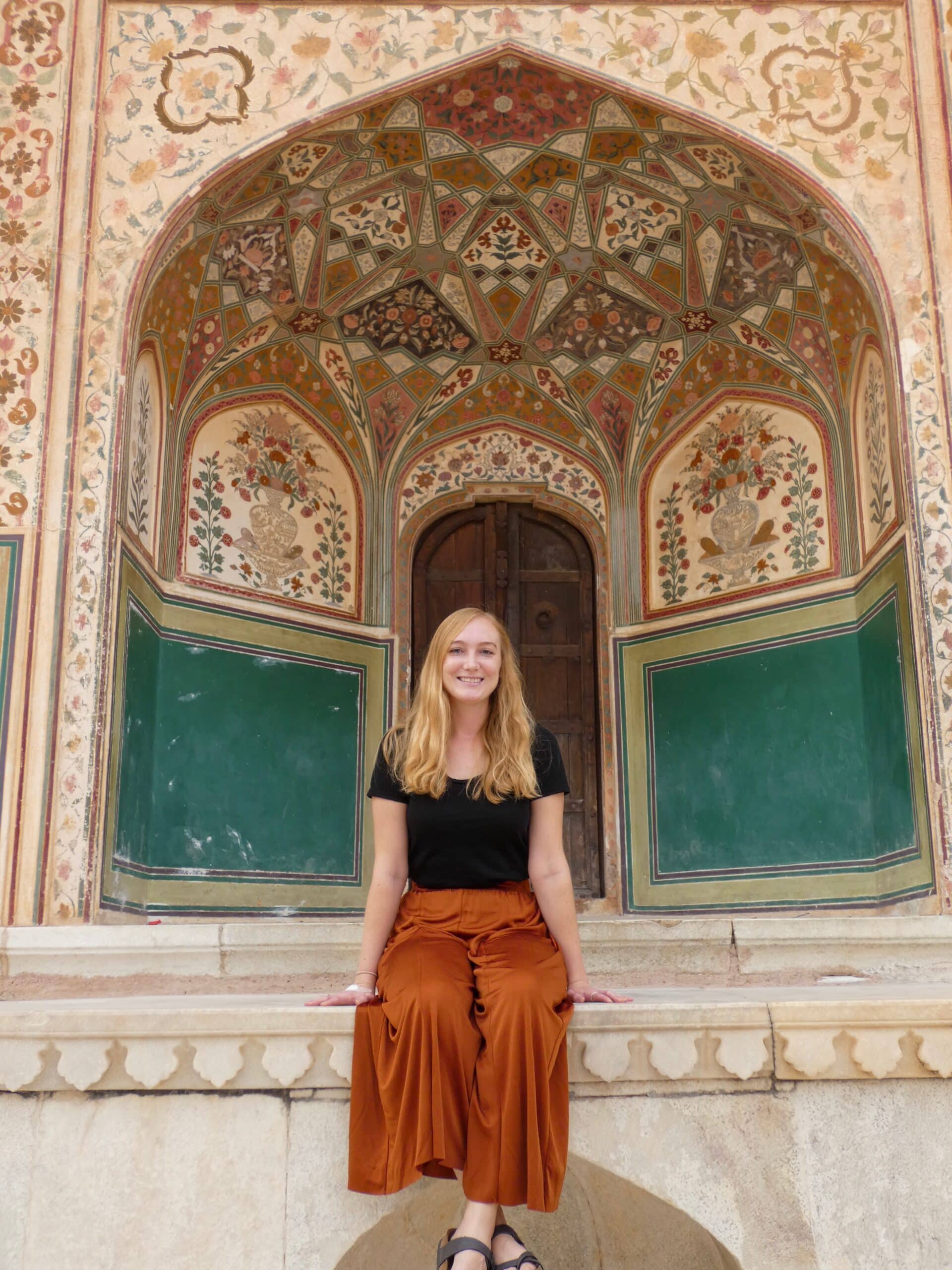 Kelsey poses in front of an intricately decorated building on vacation. 
