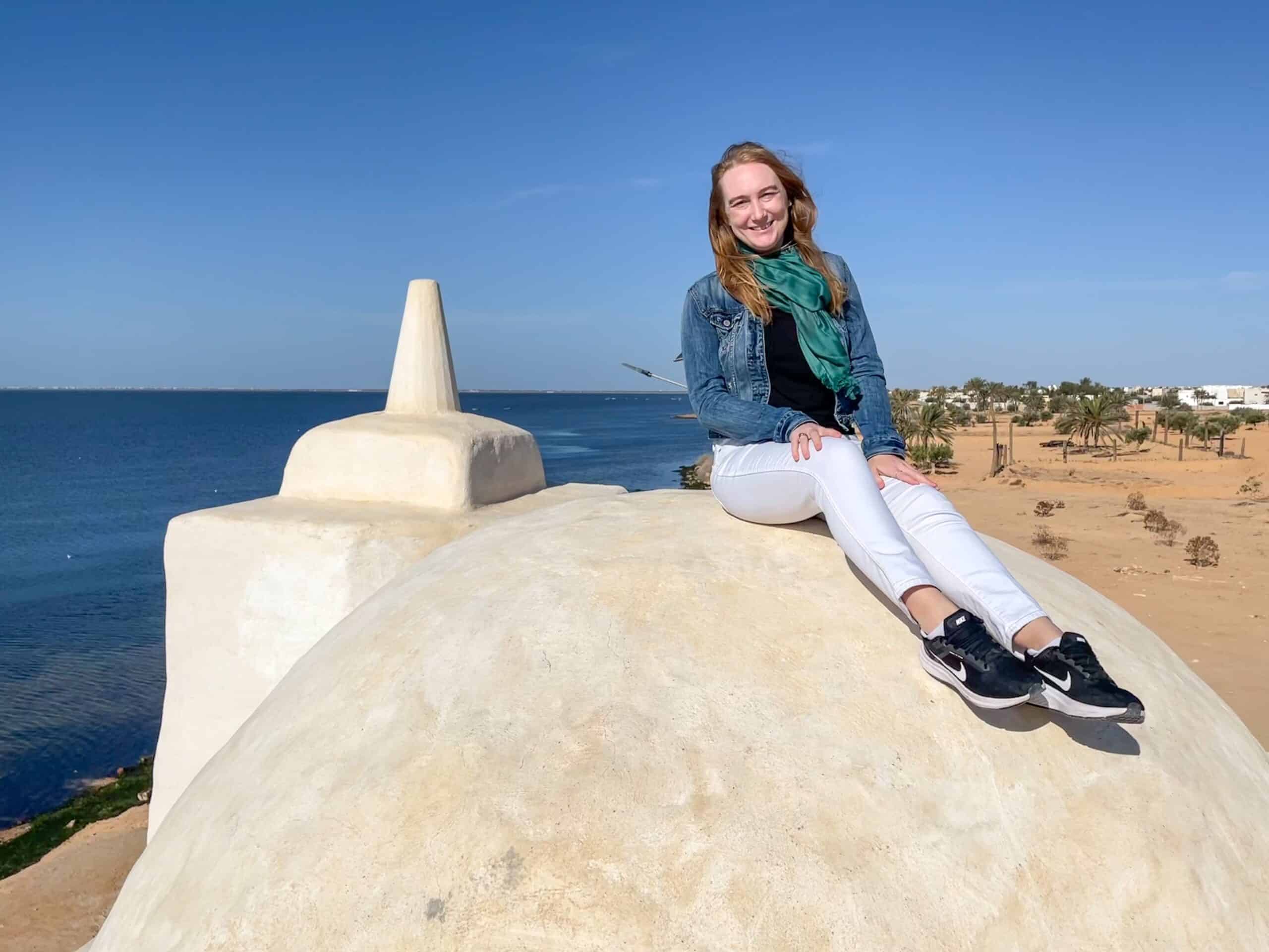Kelsey sits atop a structure near a shoreline. 