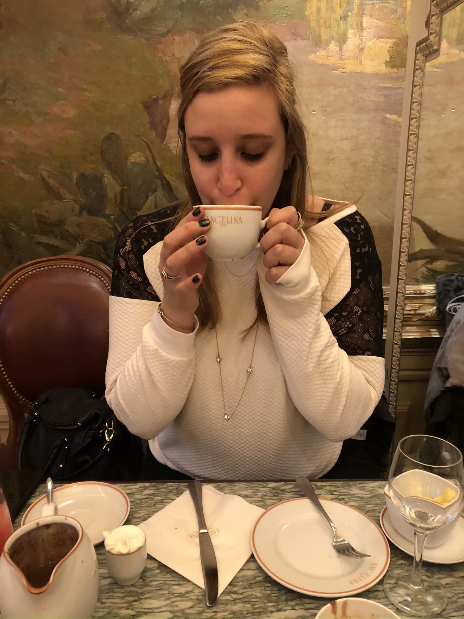 Lisa drinks from a ceramic mug.