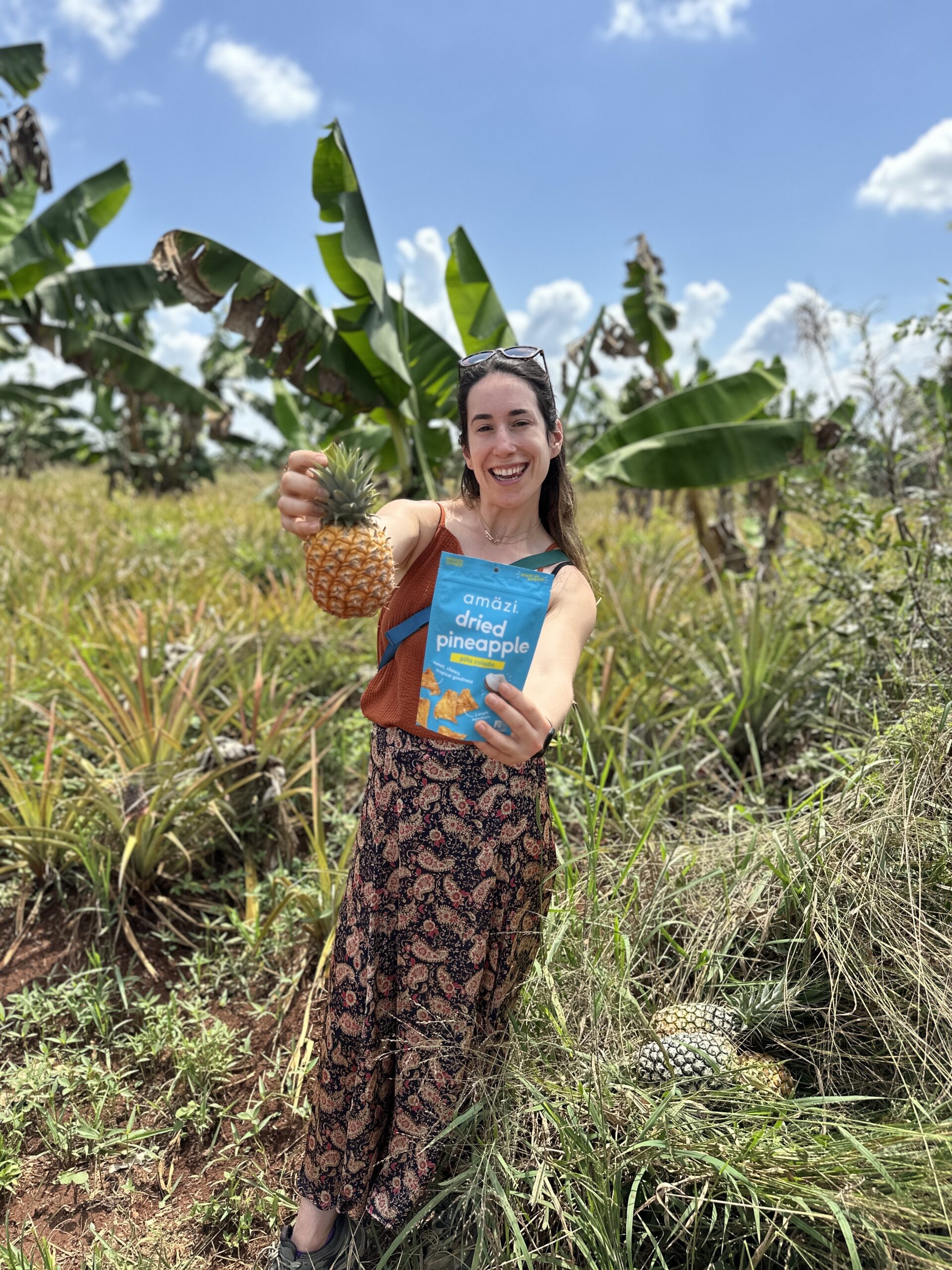 Renee with a pineapple product in a tropical landscape.