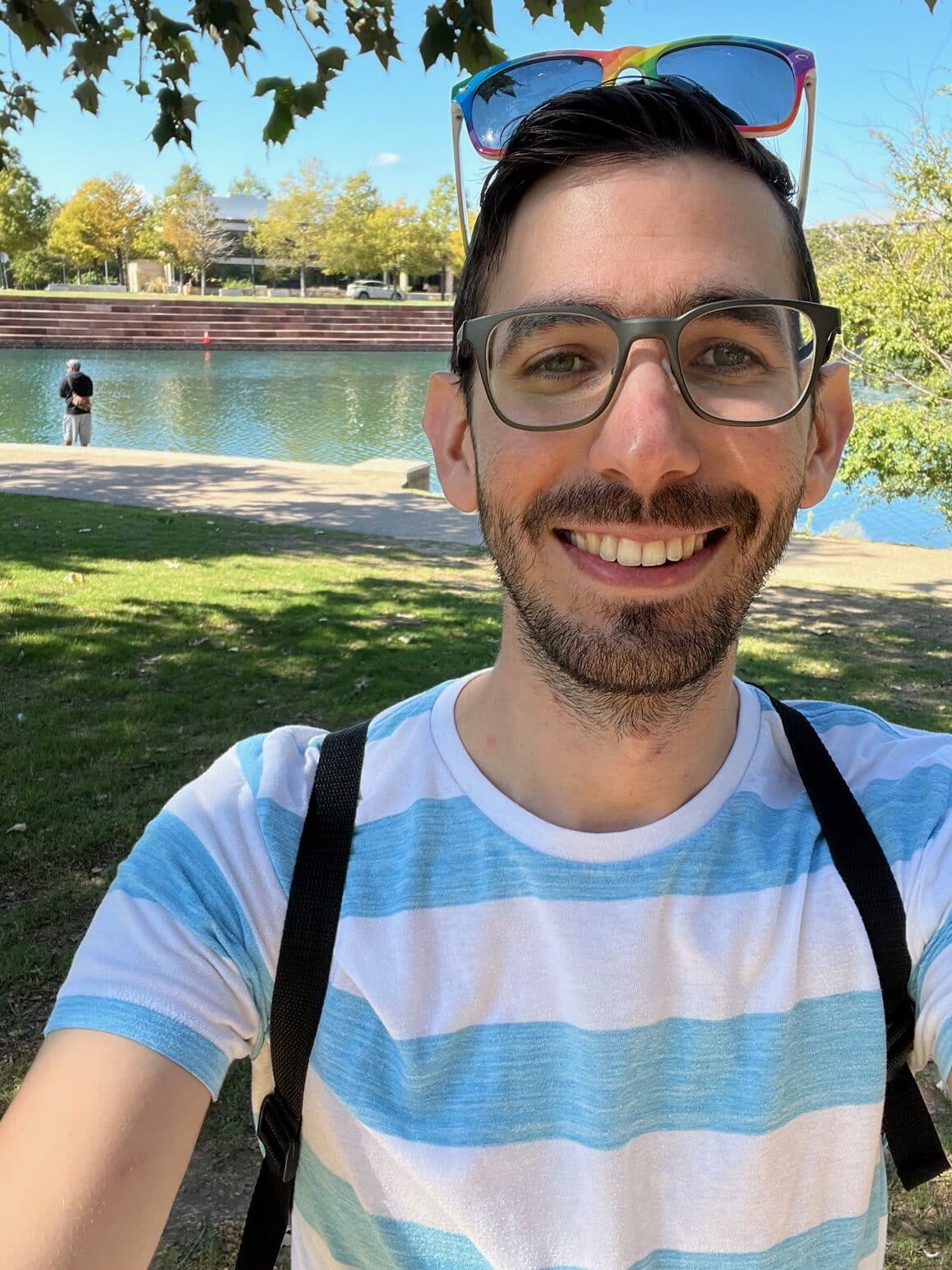 Nathan takes a selfie in front of a pond.
