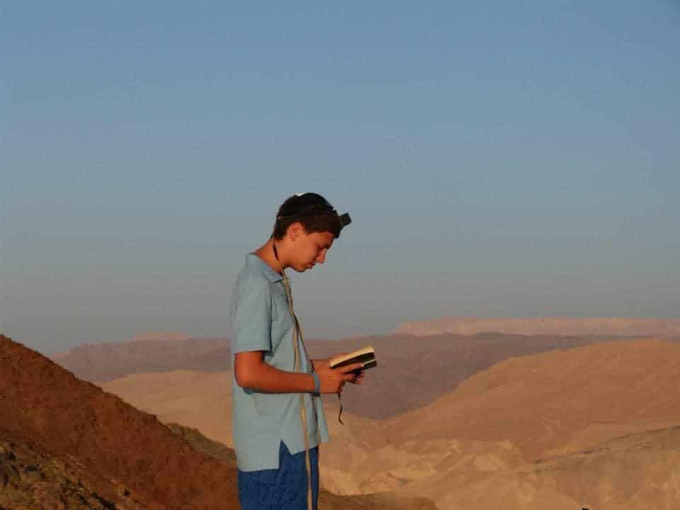 Aaron as a child, praying, in an arid landscape. 