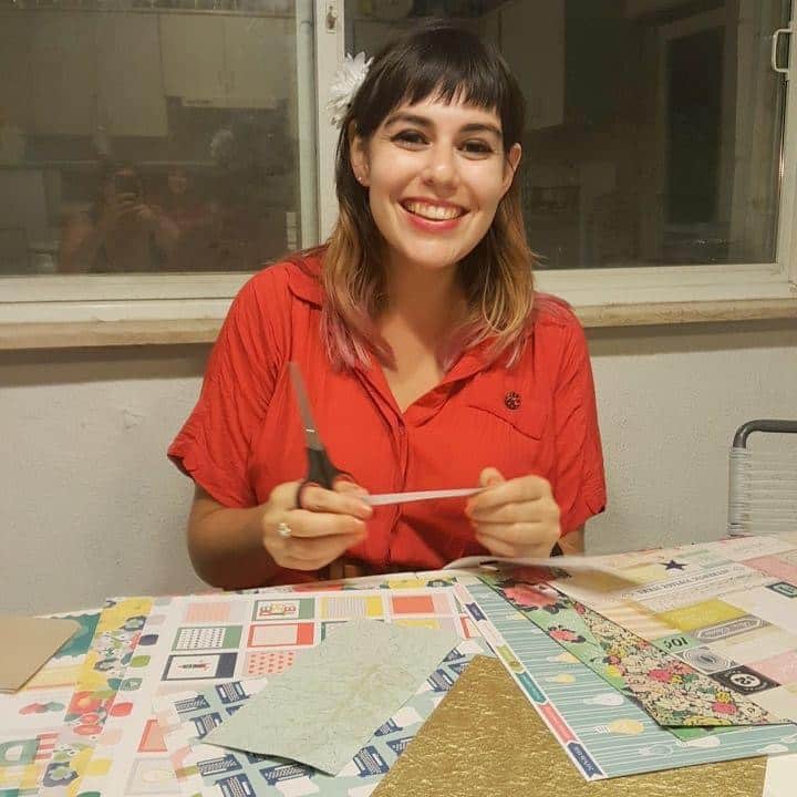 Rabbi Amalia sits at a table with scissors and patterned paper.