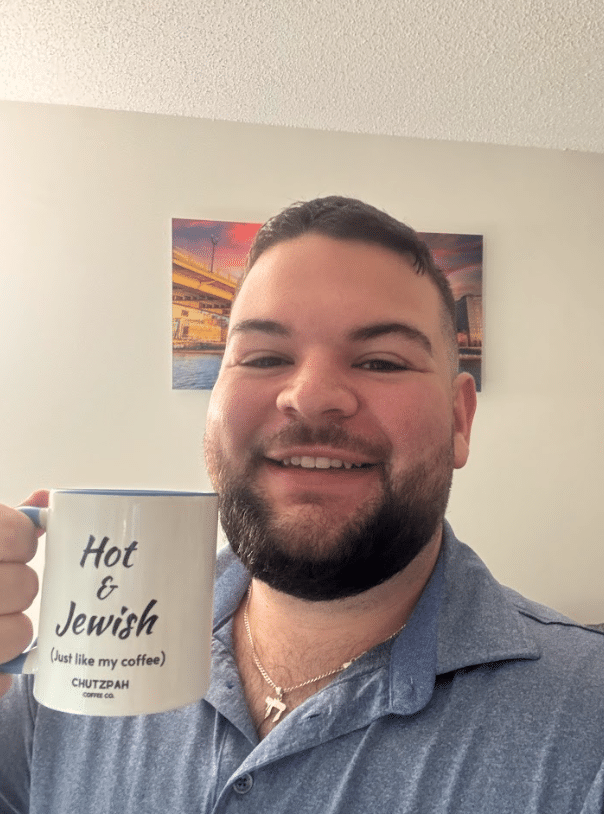 Jonathan with a coffee mug that says "Hot and Jewish."