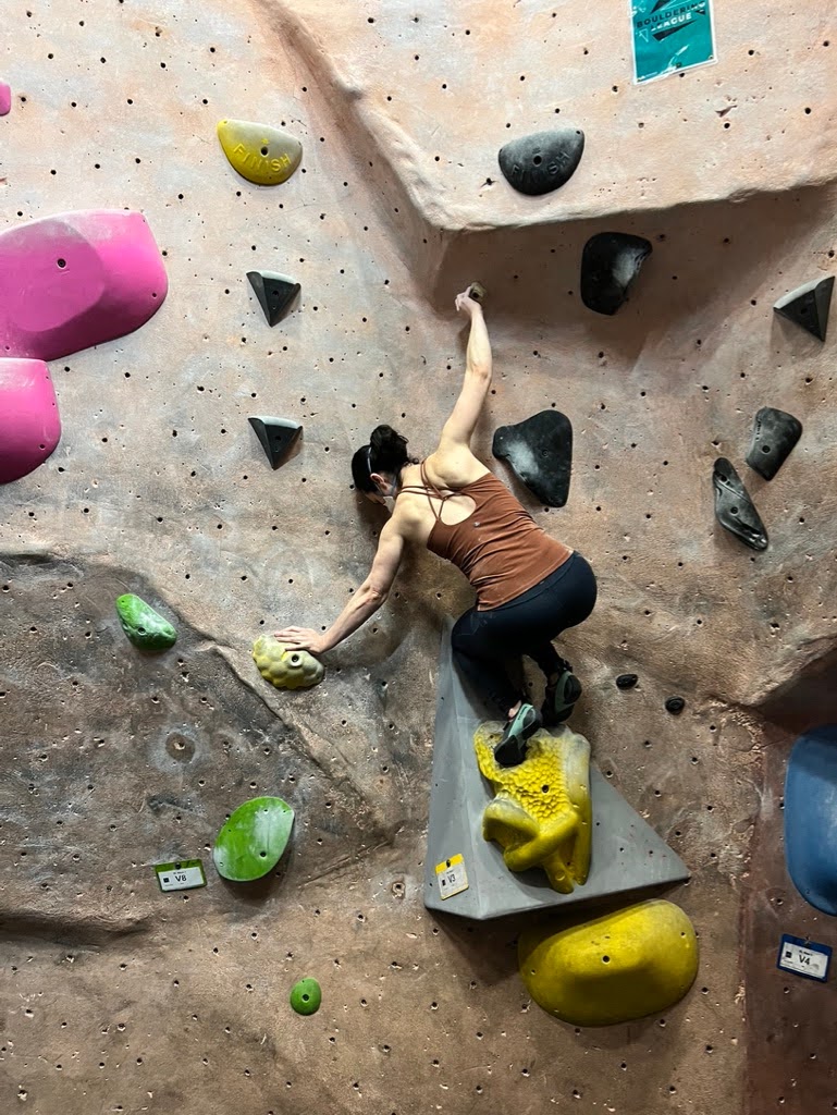 Adrienne rock climbing indoors.