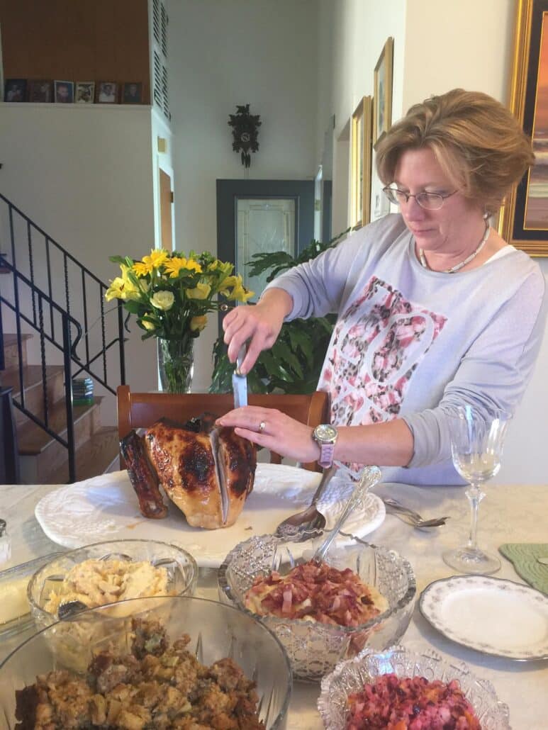 A woman carves a turkey.