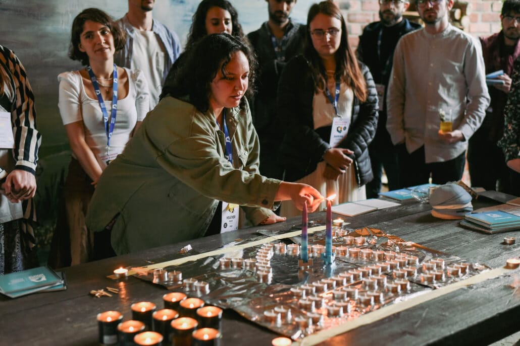 A young woman lights candles. 