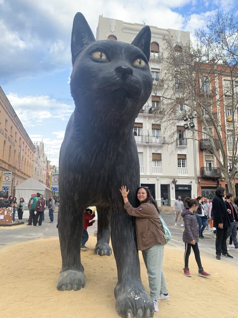 Heather with a giant statue of a black cat.