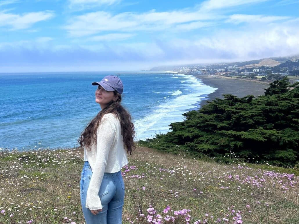 Jenna on the coast, breakers in the distance.