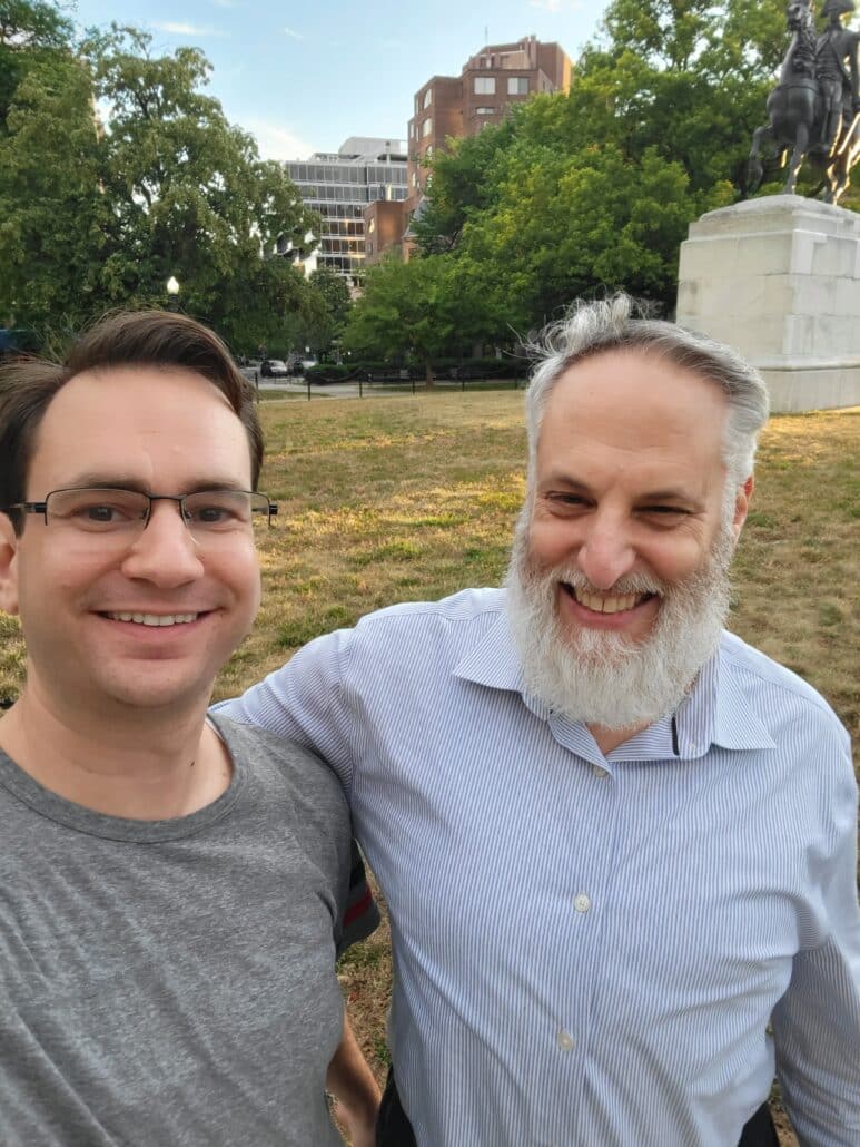 Menachem and an older man in a city park.