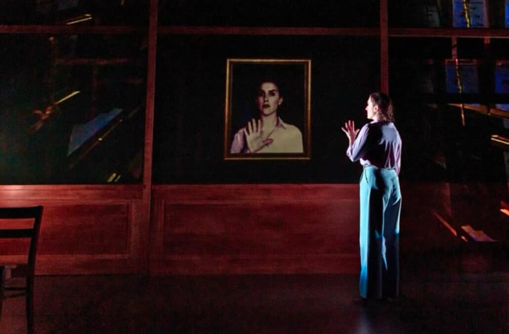 Dani looks at a portrait onstage.