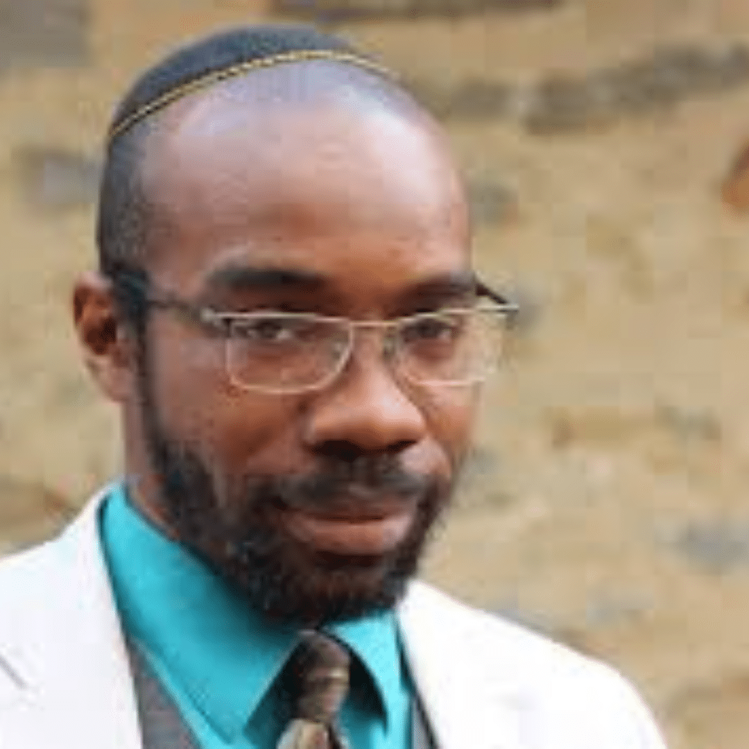 A Black man in a blue shirt, tie, glasses, and kippah.