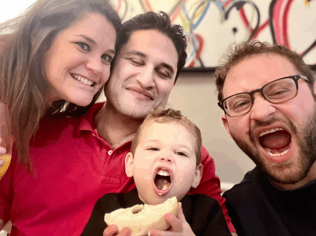 Noah with a man, woman, and child. They are making funny faces.