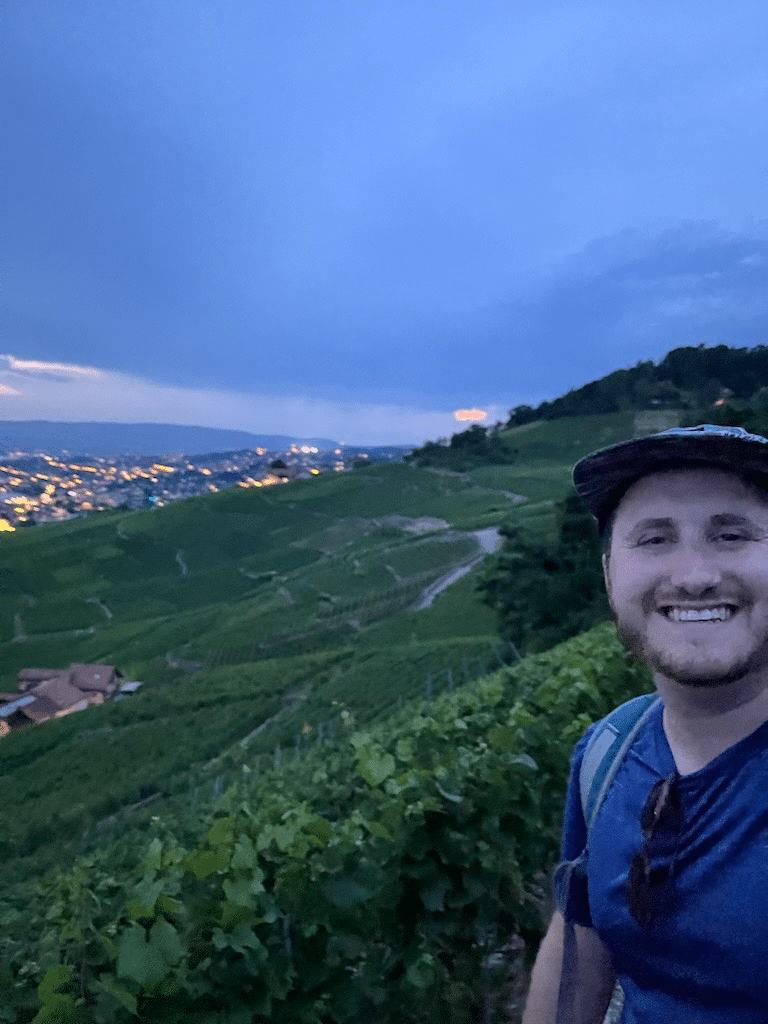 Adam on a hike overlooking a city.