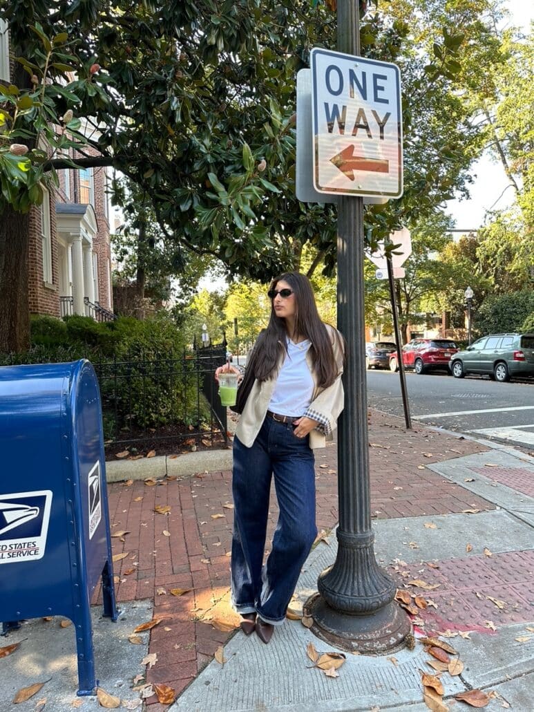 Samantha leans against a lamp post.