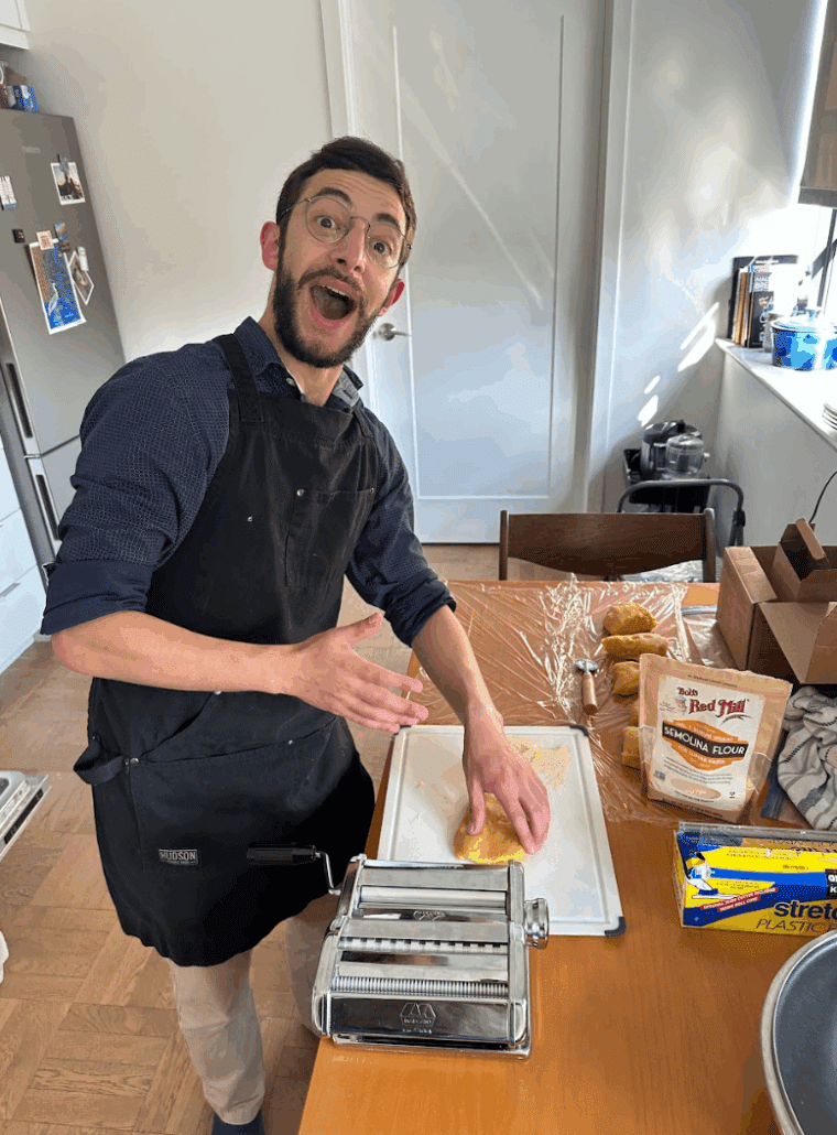Noah making pasta in a blue apron.