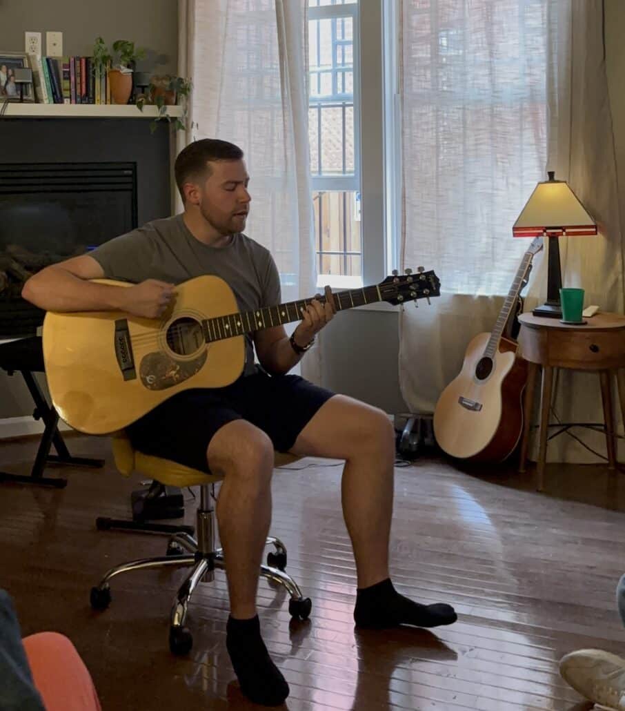 David strums a guitar.