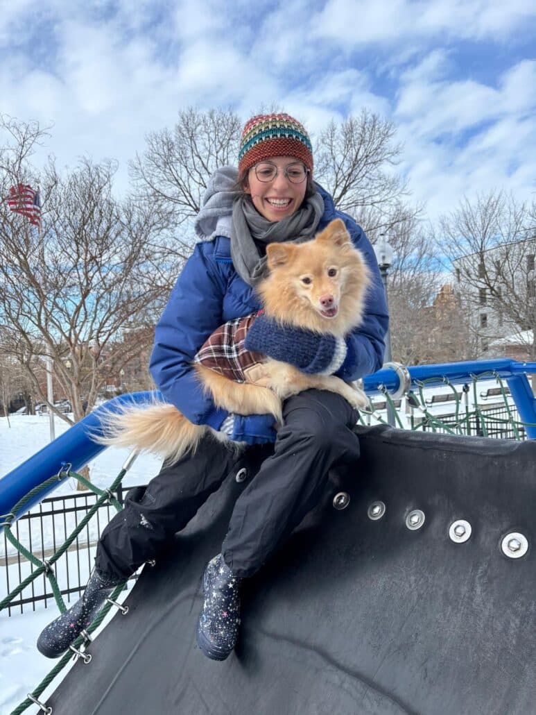Tamar holds a dog in winter.