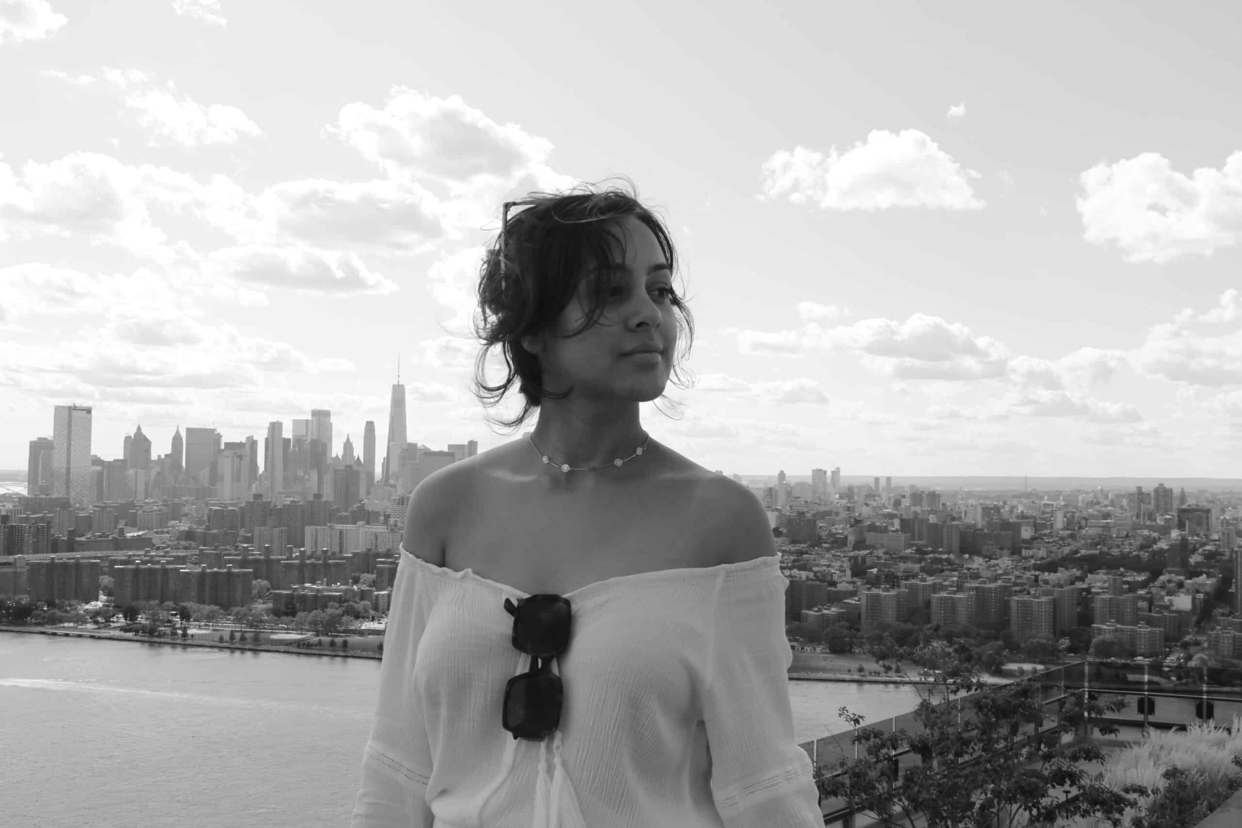 A black and white photo of Nina in front of a city skyline.