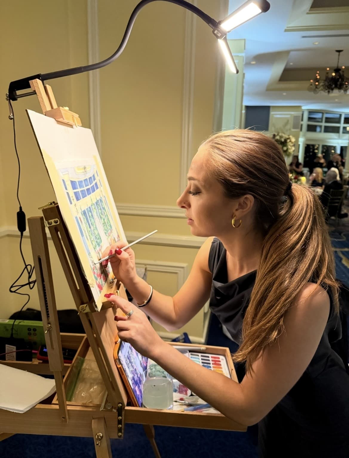 Mia painting on an easel.