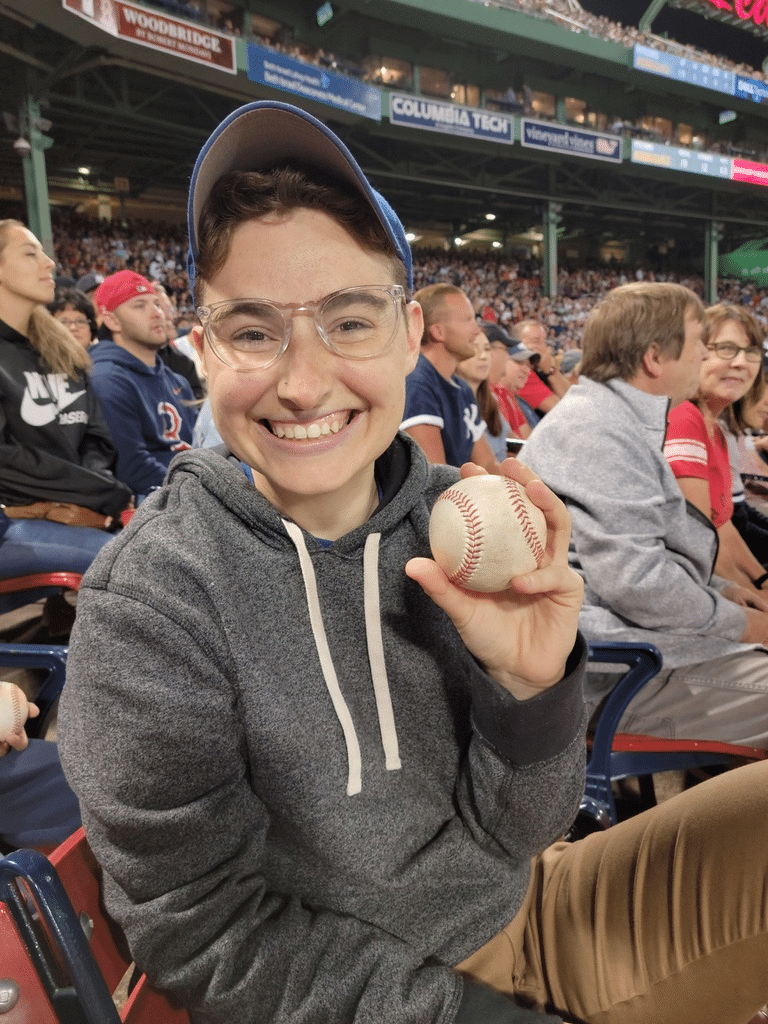 Rabbi Jenna holds a baseball at a game.