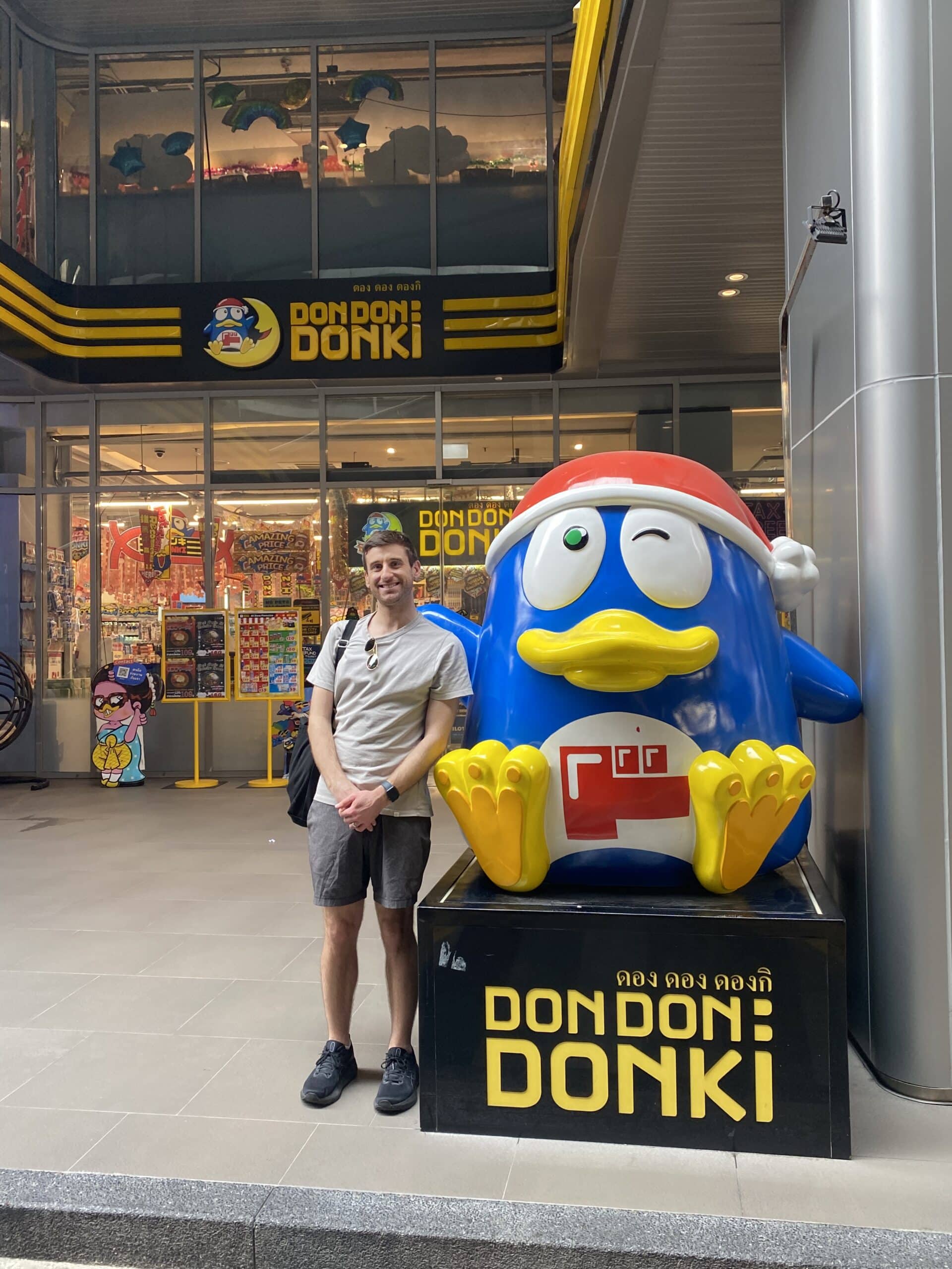 Nick with a penguin-like cartoon statue.